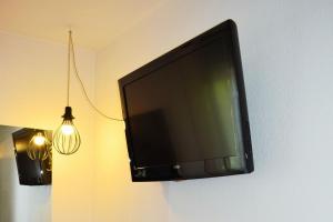 a flat screen tv hanging on a wall at Sporting House Hôtel in Toulouse +89 photos