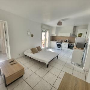a living room with a bed and a kitchen at Bel appartement avec jardin de 30m2 , climatisé avec parking et arrivée autonome in Cabestany