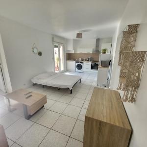 a living room with a bed and a kitchen at Bel appartement avec jardin de 30m2 , climatisé avec parking et arrivée autonome in Cabestany