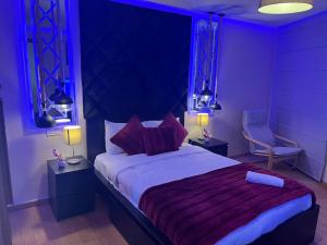 - une chambre avec un grand lit et un éclairage violet dans l'établissement Studio a Marina Casablanca, à Casablanca