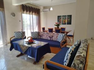 een woonkamer met een bank en een tafel bij Voulas Guest House in Volos