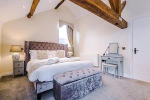 a bedroom with a large bed and a chair at Tranquil 1-bed barn in Beeston by 53 Degrees Property, ideal for Couples & Friends, Great Location - Sleeps 2 in Beeston