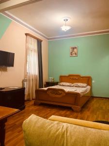 um quarto com uma cama, uma televisão e um sofá em Eco em Yerevan