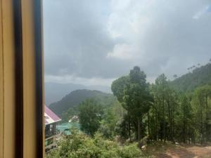 a view of a valley with trees and a building at Murree Oaks Tulip Block in Murree