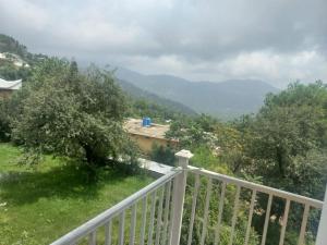 a balcony with a white fence and trees and mountains at Murree Oaks Tulip Block in Murree