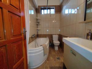 a bathroom with a tub and a toilet and a sink at Voulas Guest House in Volos
