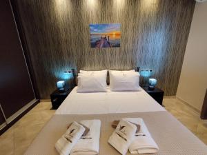 a bedroom with a bed with two towels on it at Voulas Guest House in Volos