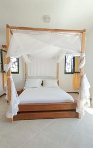 a bedroom with a bed with a canopy at BEL HORIZON Nosy Be in Nosy Be
