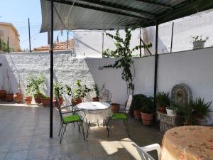 a patio with a table and chairs and plants at Voulas Guest House in Volos