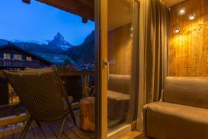 a balcony with a chair and a view of a mountain at Hotel Bellerive in Zermatt