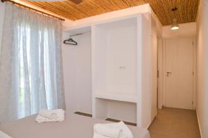 a bedroom with a bed and a large window at Mylopetra Milos Suites in Tripití