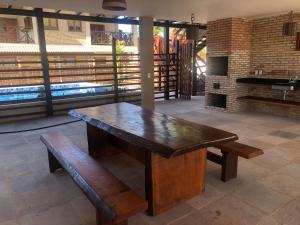 a wooden table and bench in a room with a fireplace at BEACH HOUSE - Loggia Suite 3 - com cozinha - na praia - BEACHFRONT in Barra Grande