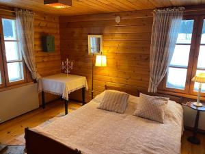 1 dormitorio con cama, mesa y ventanas en Laattajan Pirtti vuokramökki 1-5 henkilölle en Hyrynsalmi