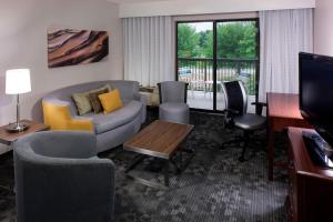 sala de estar con sofá, sillas y TV en Courtyard by Marriott Wichita East, en Wichita