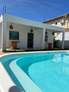 a swimming pool in front of a house at Casa Arembepe in Camaçari