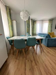 ein Wohnzimmer mit einem Esstisch und Stühlen in der Unterkunft Al-Dom Apartamenty Olymp 204 in Kołobrzeg