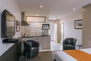 Habitación de hotel con 1 cama y 2 sillas en Motel 429 en Hobart