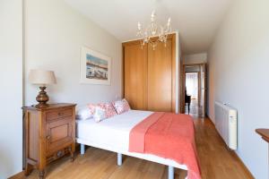 1 dormitorio con cama y lámpara de araña en Baiona Playa, en Baiona