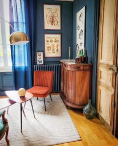 - un salon avec une chaise rouge et une table dans l'établissement Domaine Le Clos de la Source - Petit déjeuner buffet, à Montrichard
