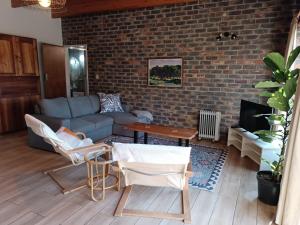 a living room with a couch and a brick wall at Boekenhout Accommodation in Pretoria