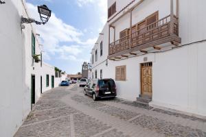a car parked on a street between two buildings at Balcon de Porteria in Telde