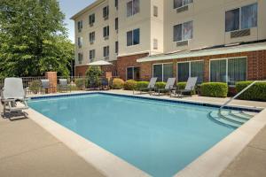 een groot zwembad met stoelen en een gebouw bij Fairfield Inn & Suites Roanoke Hollins/I-81 in Roanoke