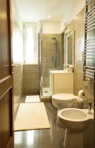 a bathroom with two toilets and a sink and a shower at Delizioso Loft nel Casale con giardino in Olgiata