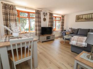 a living room with a couch and a tv at Cock Bank Cottage in Wrexham