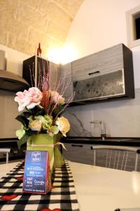 un vase de fleurs sur une table dans une cuisine dans l'établissement Casa Grazia, à Monopoli