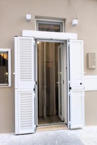 une porte ouverte dans une pièce avec volets blancs dans l'établissement Casa Grazia, à Monopoli