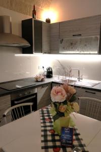 - une cuisine avec une table et des fleurs dans l'établissement Casa Grazia, à Monopoli