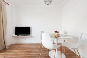 een witte eetkamer met een tafel en stoelen bij Apartamento Aigon in Puerto de la Cruz