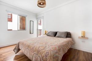 een witte slaapkamer met een bed en 2 ramen bij Apartamento Aigon in Puerto de la Cruz