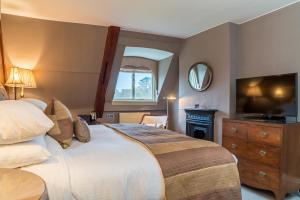 a bedroom with a large bed and a television at Stapleford Park Hotel & Spa in Melton Mowbray