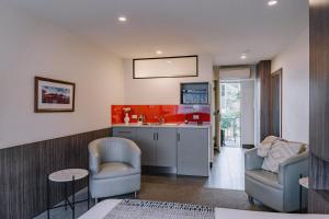 sala de estar con 2 sillas y cocina en Motel 429 en Hobart