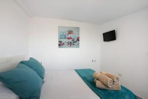 una camera da letto con un letto con cuscini blu e una TV di Bisangel House a Icod de los Vinos