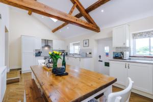a kitchen with white cabinets and a wooden table at Luxurious 3-bed barn in Beeston by 53 Degrees Property, ideal for Families & Groups, Great Location - Sleeps 6 in Beeston