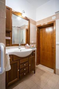 La salle de bains est pourvue d'un lavabo et d'un miroir. dans l'établissement Maiolica Rooms Appartamento Ragusa Ibla, à Raguse