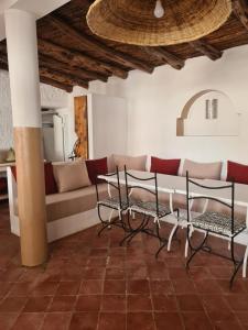 a living room with a couch and a table and chairs at La Maison des Vagues in Sidi Kaouki