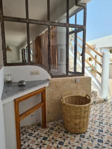 a kitchen with a counter and a basket on a floor at La Maison des Vagues in Sidi Kaouki