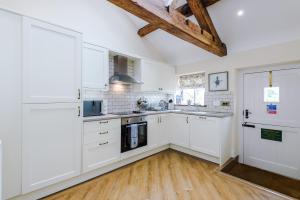 uma cozinha com armários brancos e piso em madeira em Beautiful 1-bed cottage in Beeston by 53 Degrees Property, ideal for Couples & Friends, Great Location - Sleeps 2 em Beeston