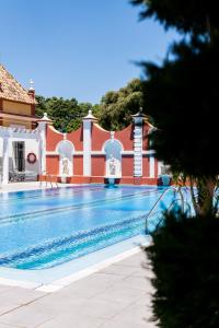 a swimming pool in front of a house at Hotel Hacienda Montenmedio in Vejer de la Frontera