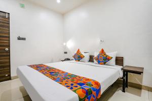 a bedroom with a bed with a colorful blanket on it at FabHotel Lotus I in Surat