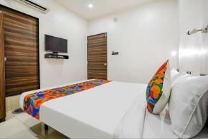 a bedroom with a bed and a tv on the wall at FabHotel Lotus I in Surat
