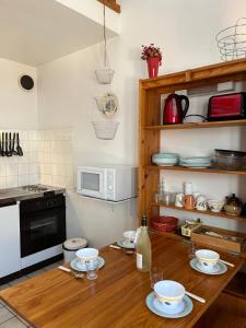 una cocina con una mesa de madera con platos. en Appartement Oz en Oisans en Oz