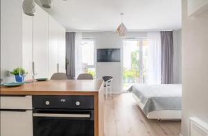 a bedroom with a bed and a kitchen with a desk at LuxApartmentWarszawa z bezpłatnym podziemnym parkingem in Warsaw