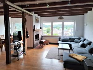 a living room with a blue couch and a fireplace at Haus mit idyllischem Seeblick in Schalkenmehren