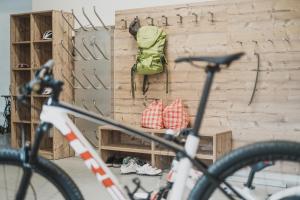 Ragitt Stodl Ferienwohnungen في Vols am Schlern: دراجة متوقفة بجوار جدار مع حقيبة ظهر خضراء