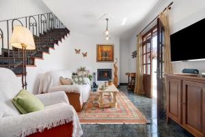 a living room with white furniture and a staircase at Las Monarcas in Teror