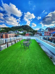 a group of tables on the roof of a building with green grass at Namsan Guesthouse in Seoul